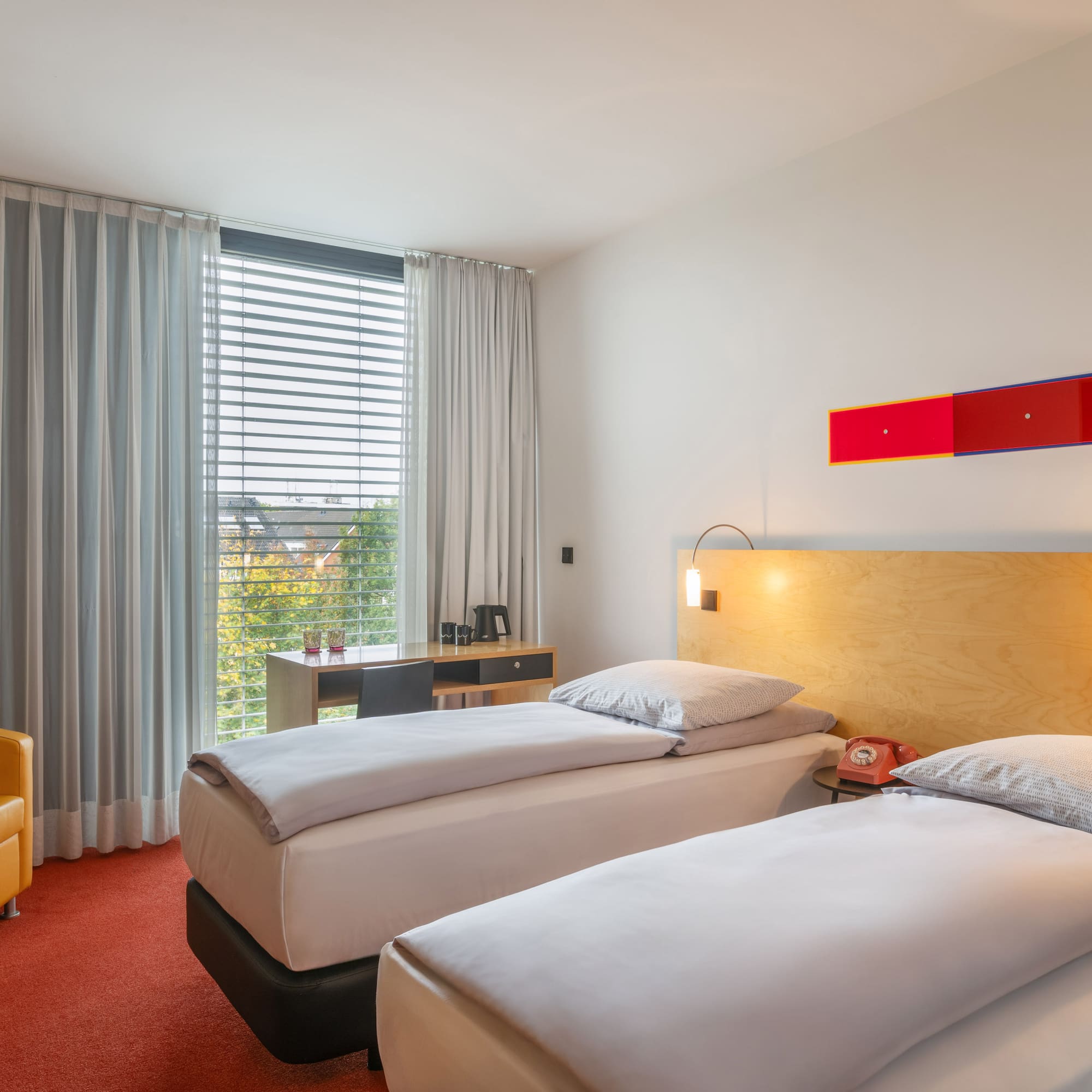 a room with two beds and a yellow chair