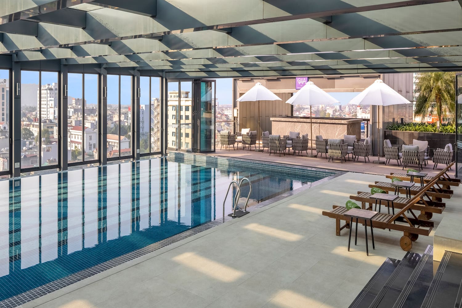 a pool with chairs and umbrellas in a building