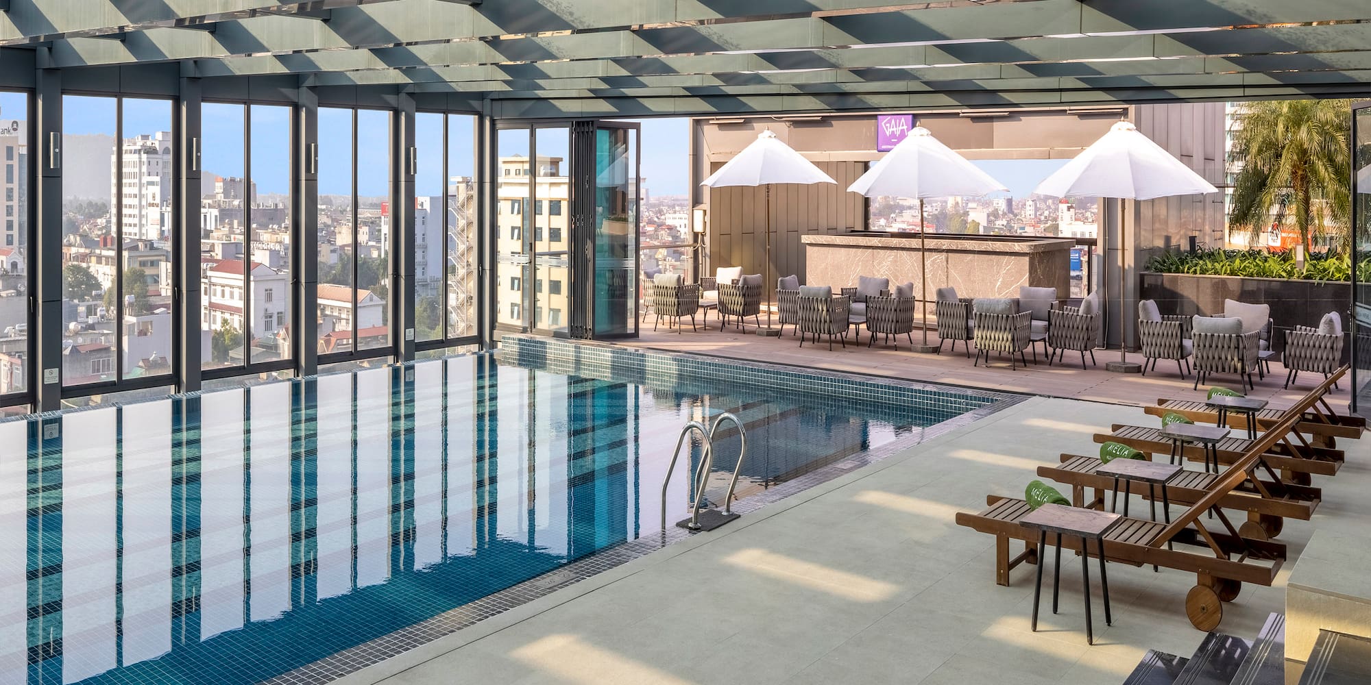 a pool with chairs and umbrellas in a building
