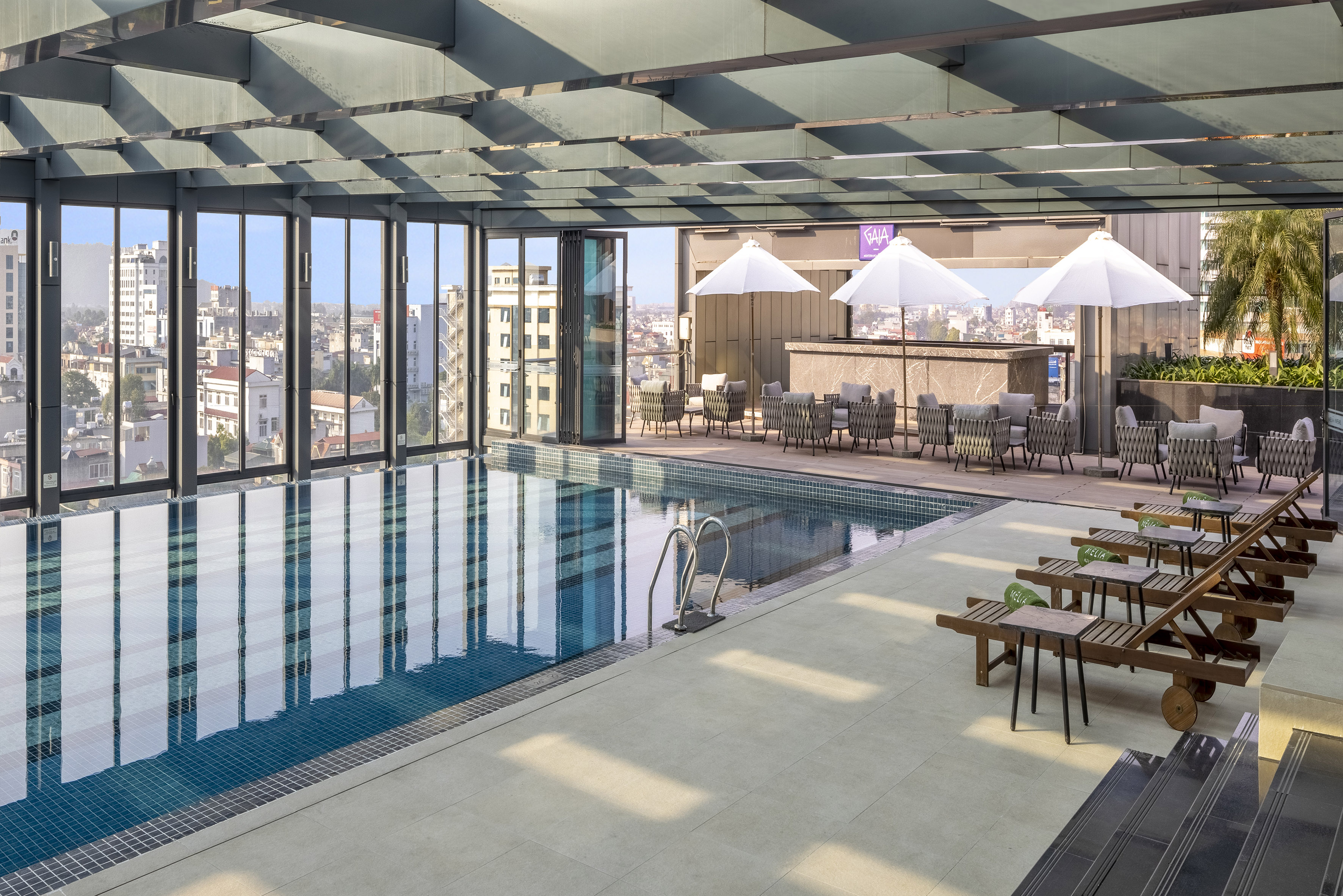 a pool with chairs and umbrellas in a building