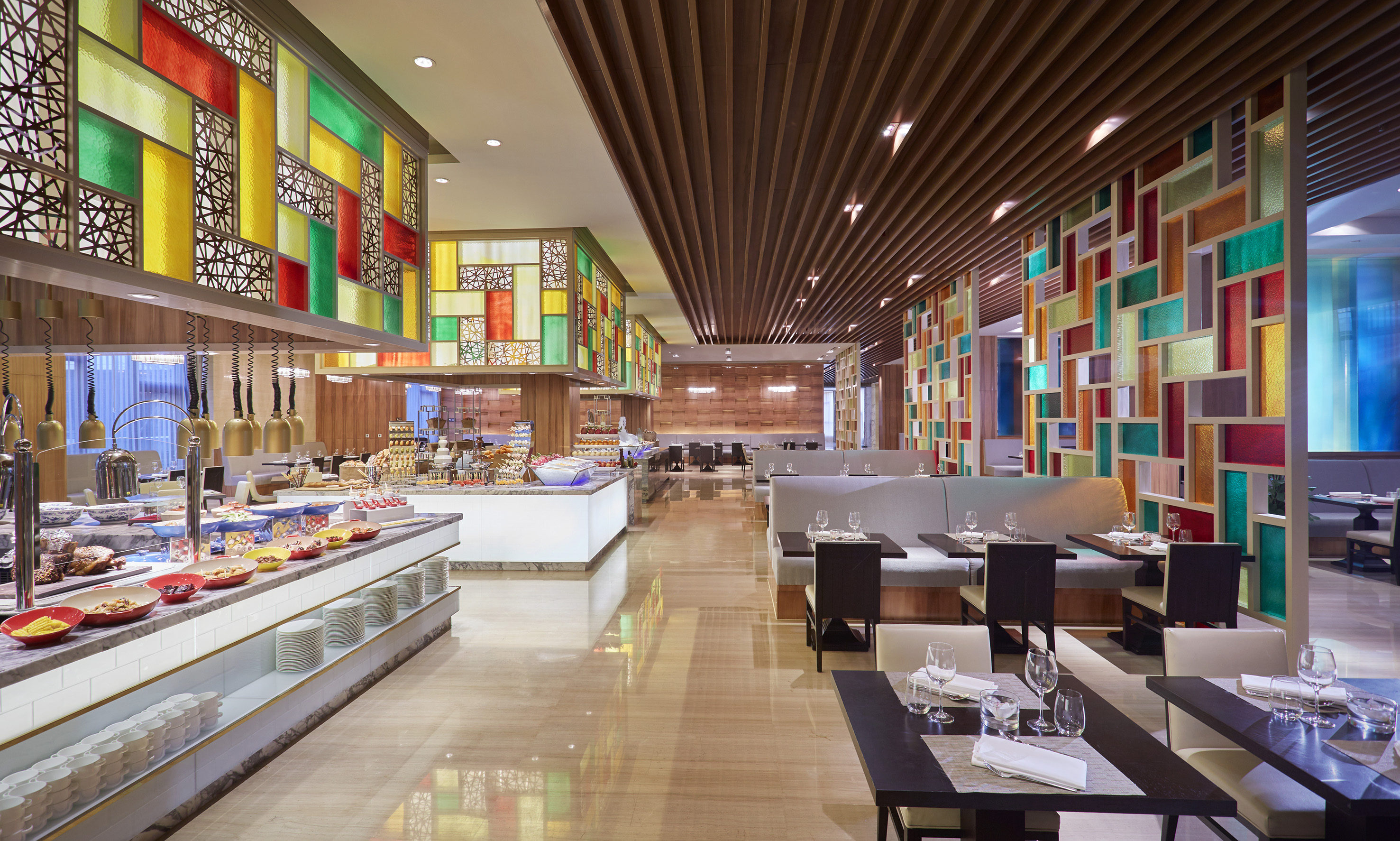 Vibrant buffet restaurant interior with mosaic partitions and dining tables.