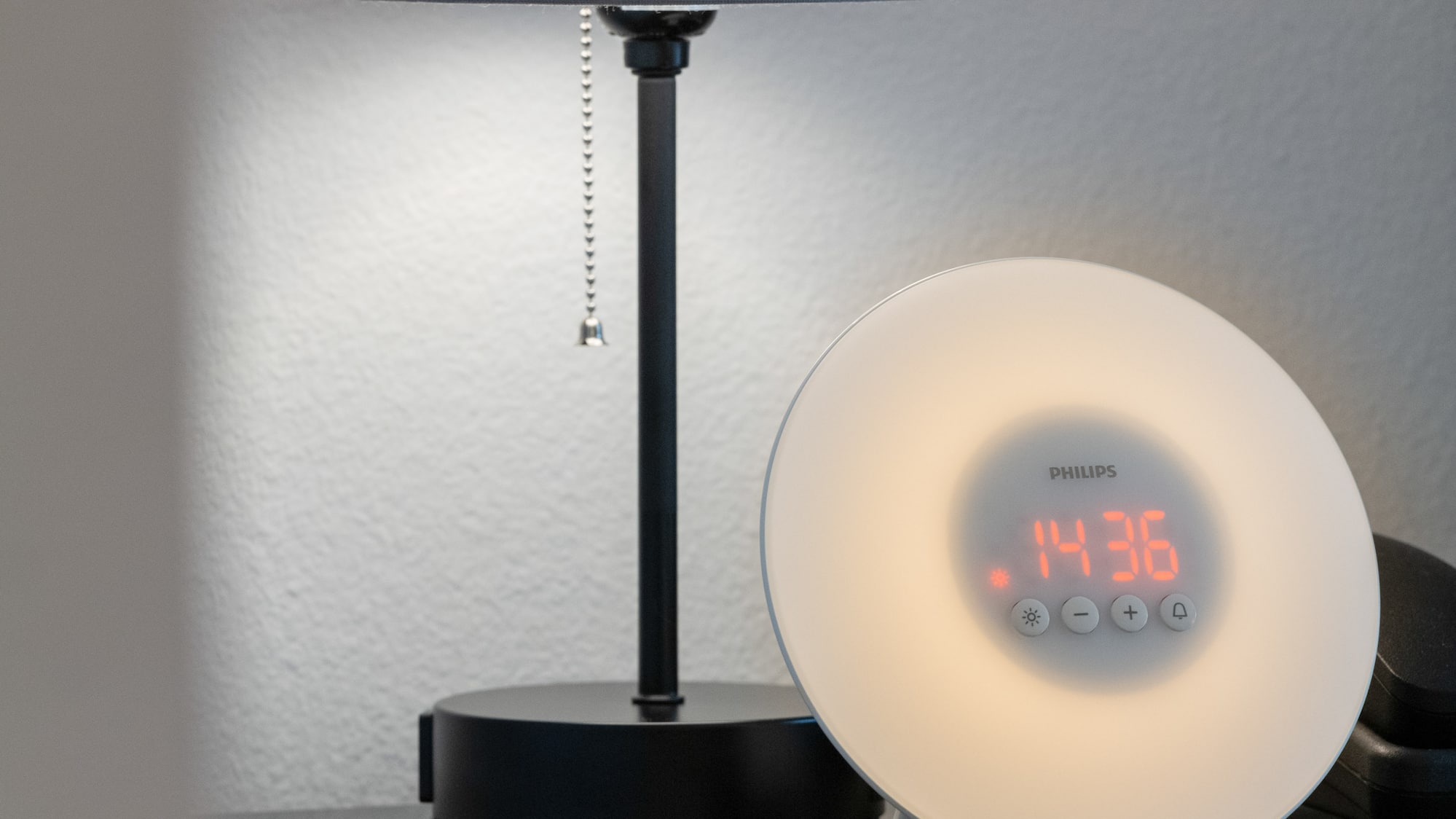 a clock on a table next to a lamp