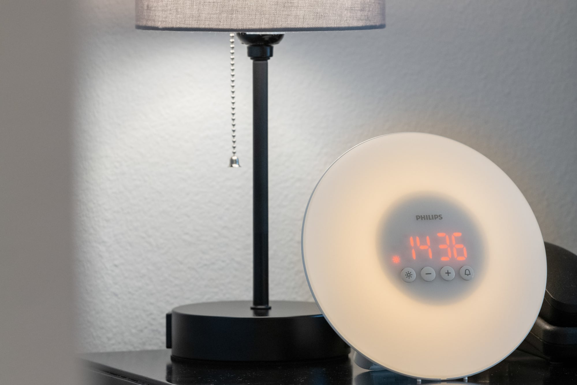 a clock on a table next to a lamp