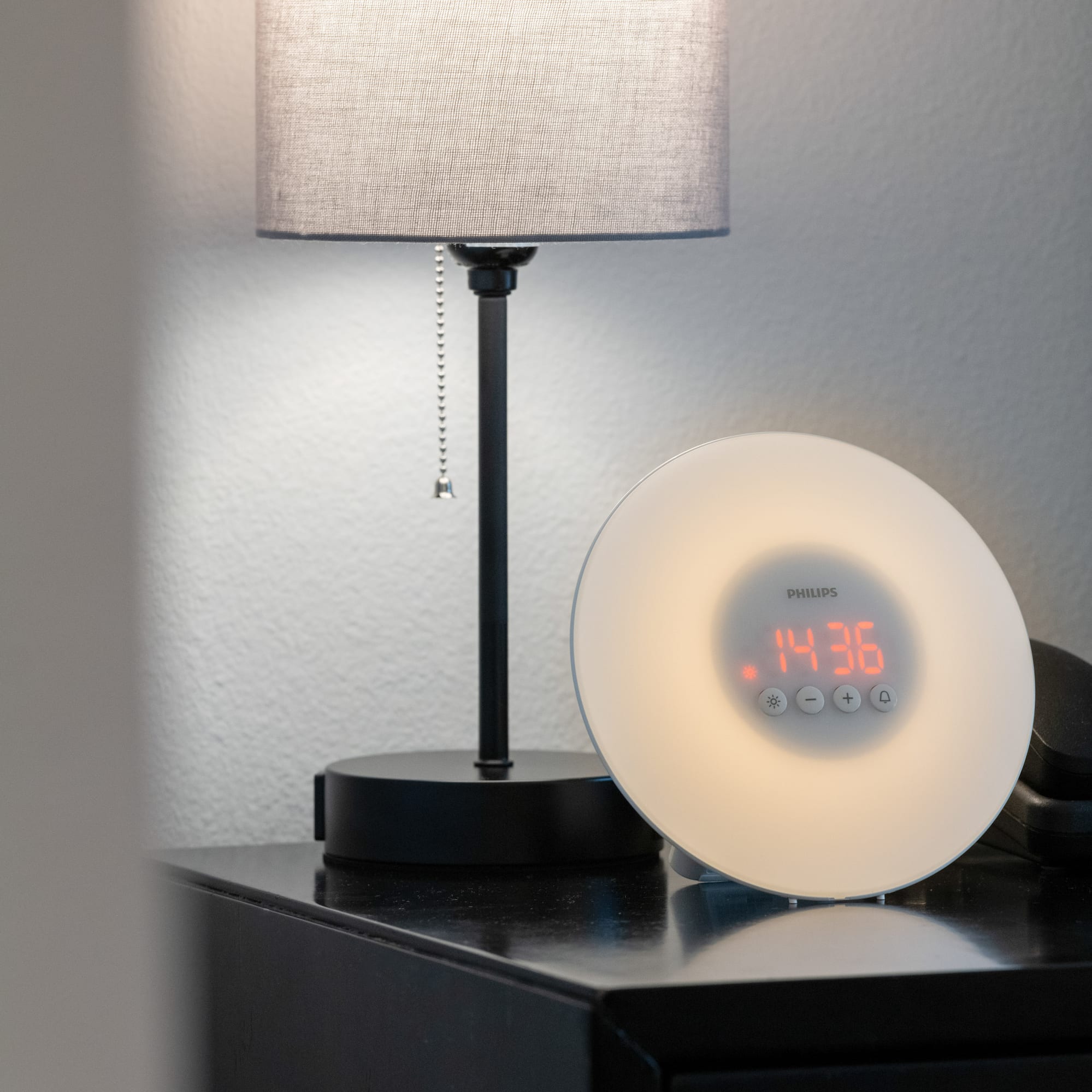 a clock on a table next to a lamp