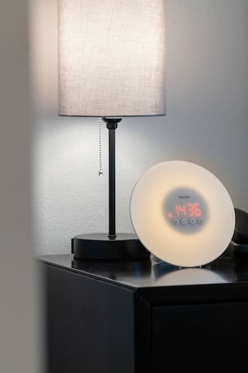 a clock on a table next to a lamp