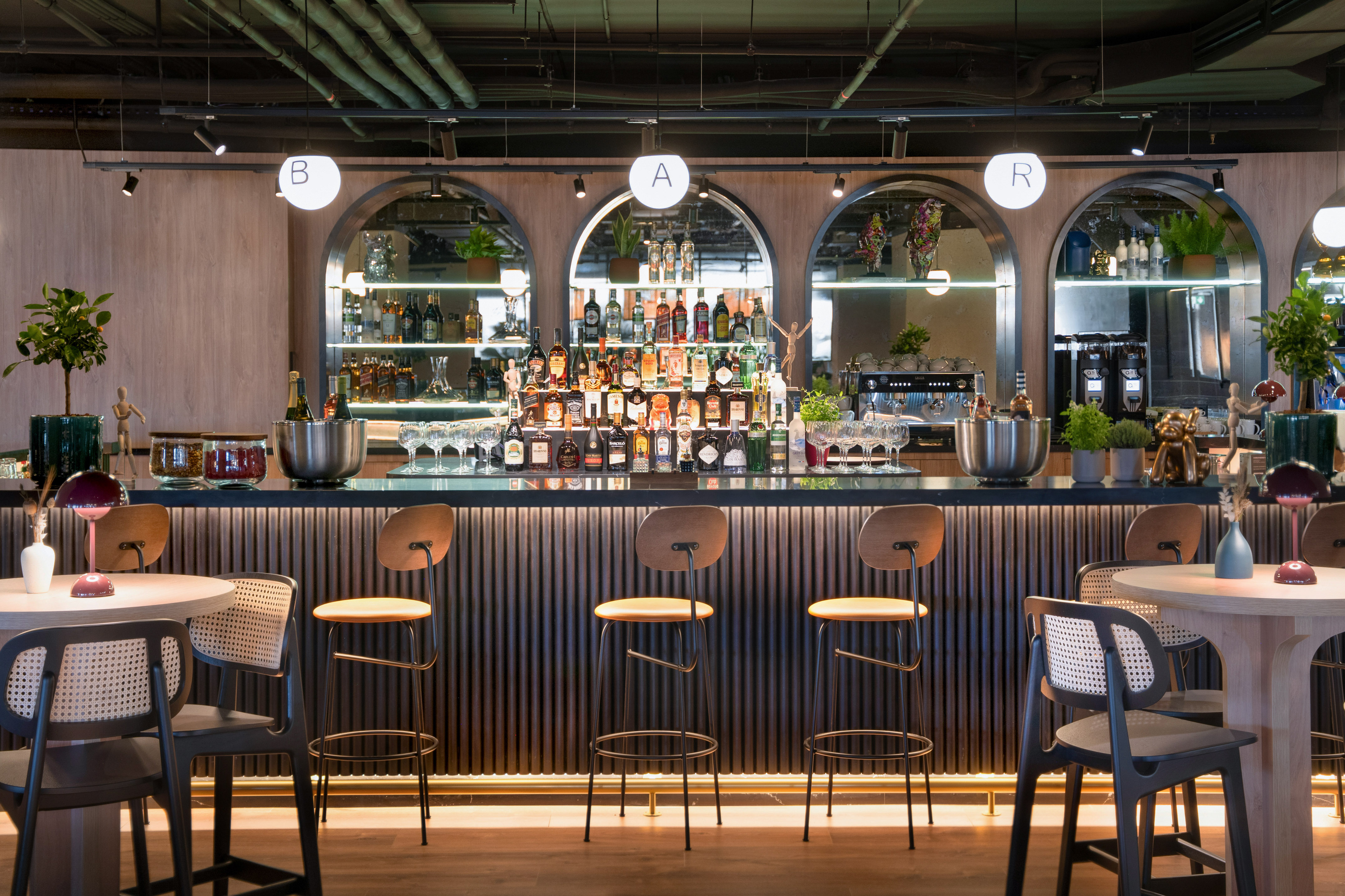 Modern cocktail bar with diverse liquor, bar stools, and inviting ambiance.
