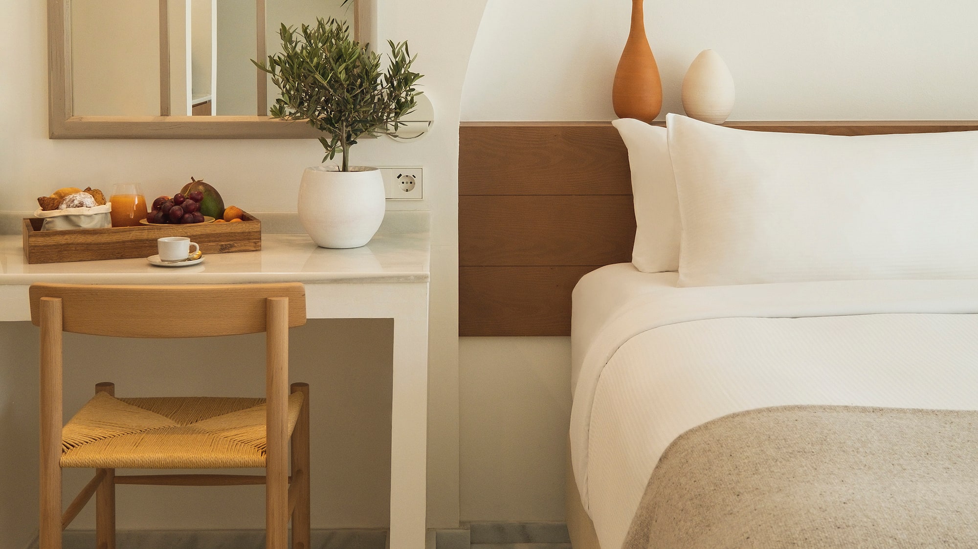 a bed with a chair and a table with a plant on it