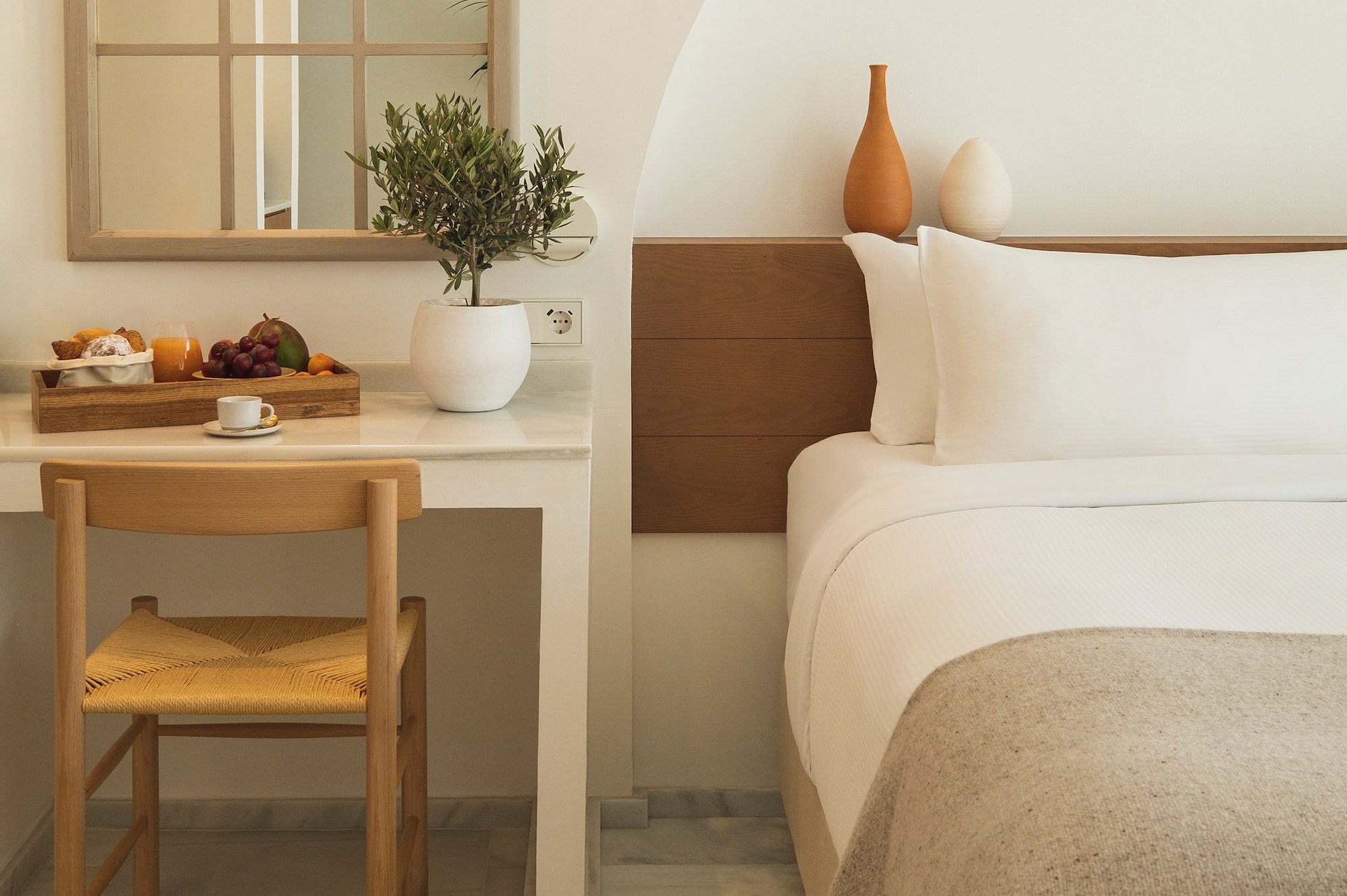 a bed with a chair and a table with a plant on it