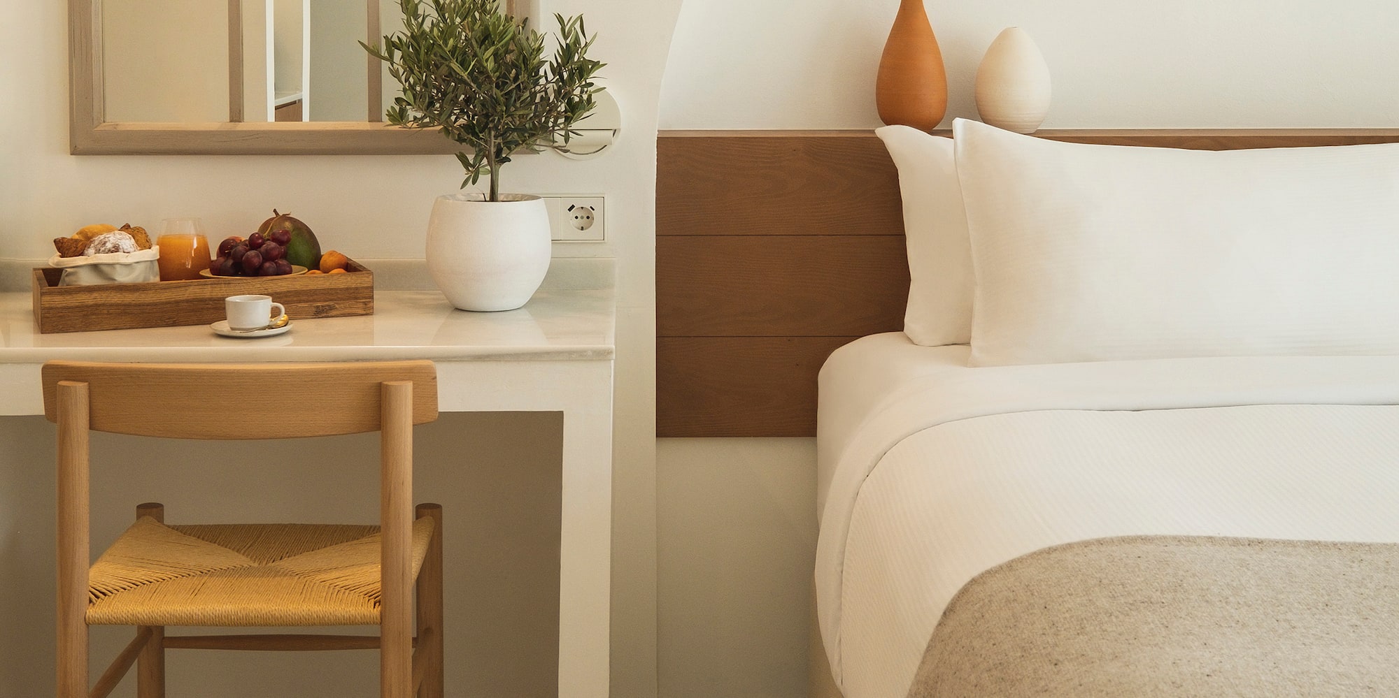 a bed with a chair and a table with a plant on it