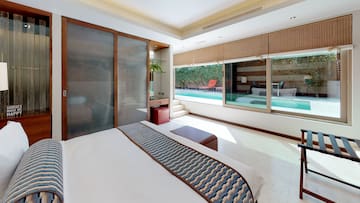 a bedroom with a bed and a pool in the background