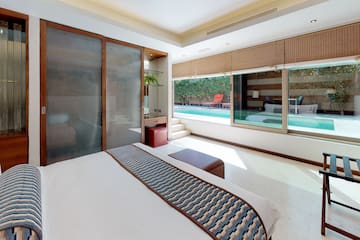 a bedroom with a bed and a pool in the background