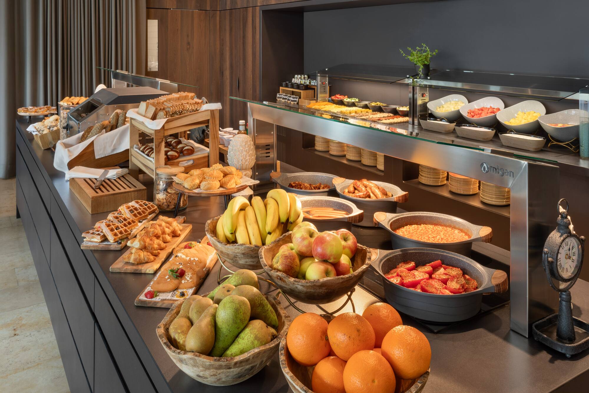 Extensive breakfast buffet with fresh fruits, pastries, hot dishes, and assorted breads.