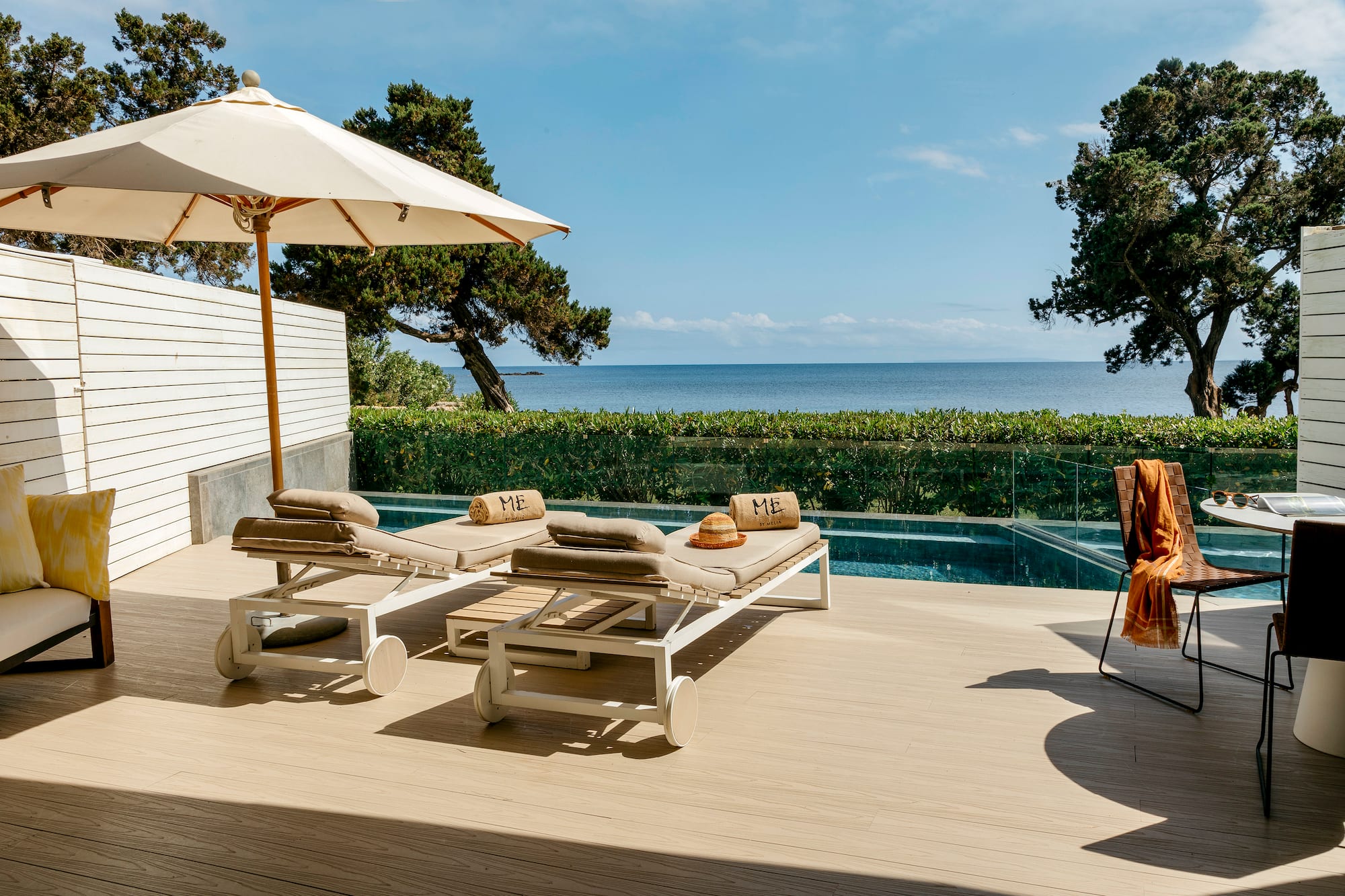 a deck with chairs and umbrellas on a deck overlooking a body of water