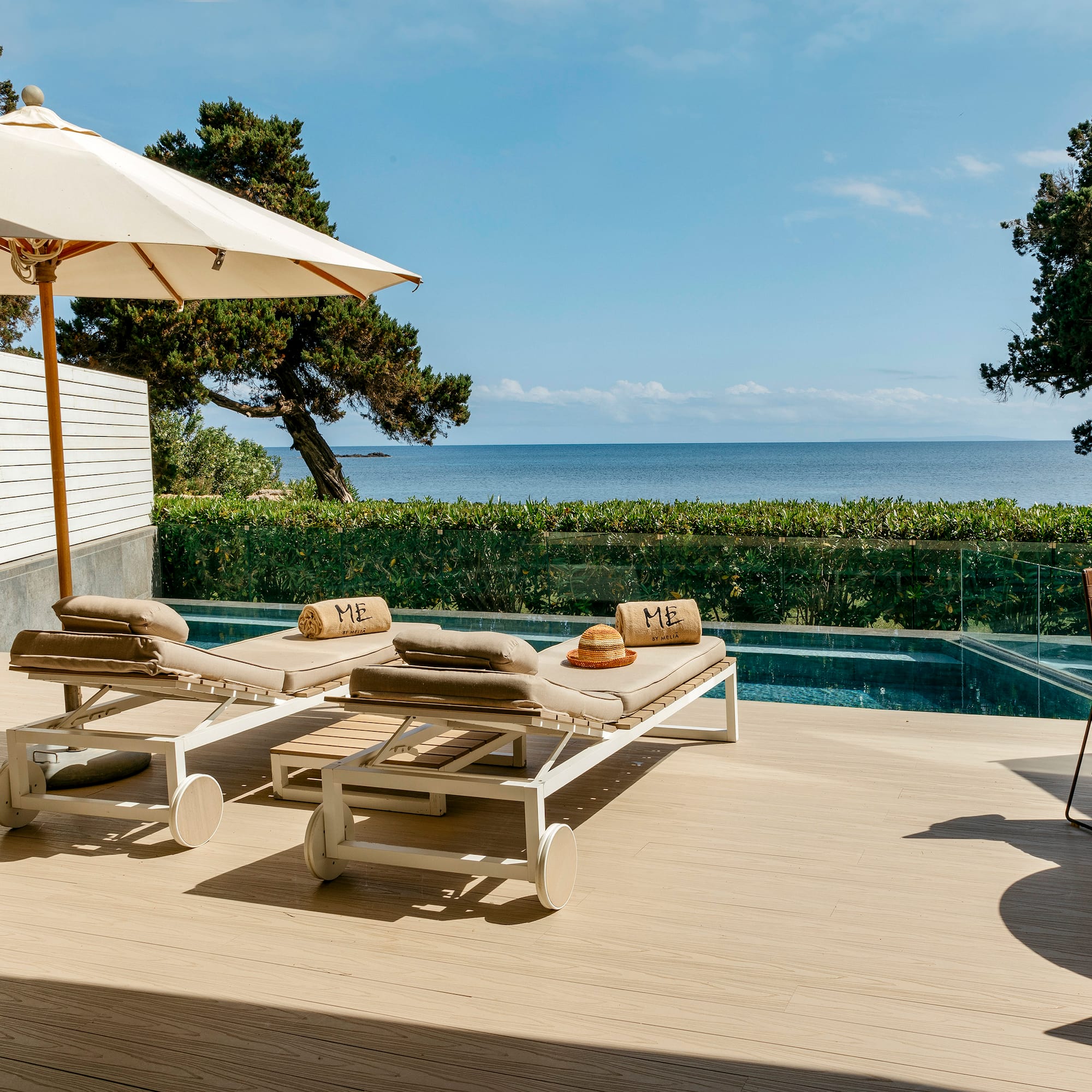 a deck with chairs and umbrellas on a deck overlooking a body of water