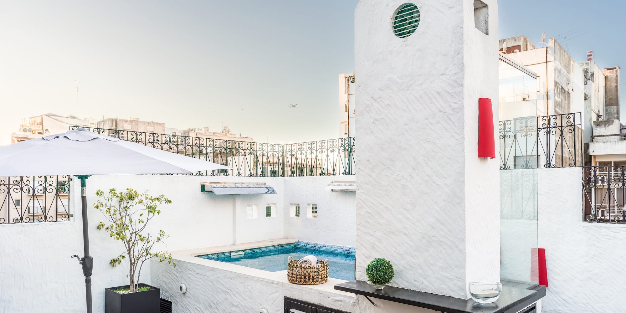 a pool with a hot tub on a rooftop