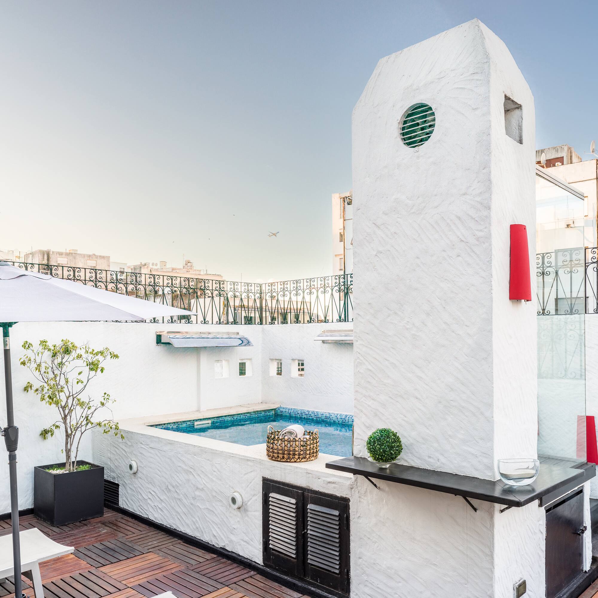 a pool with a hot tub on a rooftop