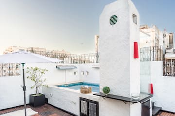 a pool with a hot tub on a rooftop