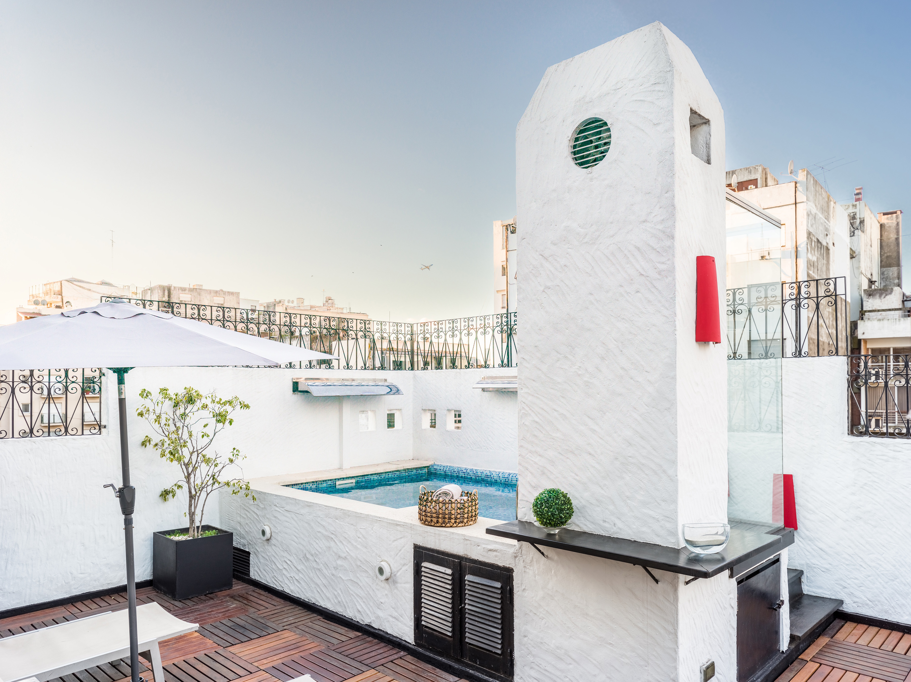 a pool with a hot tub on a rooftop