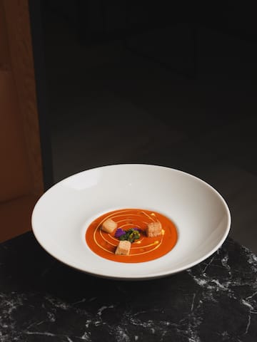 a bowl of soup on a marble table