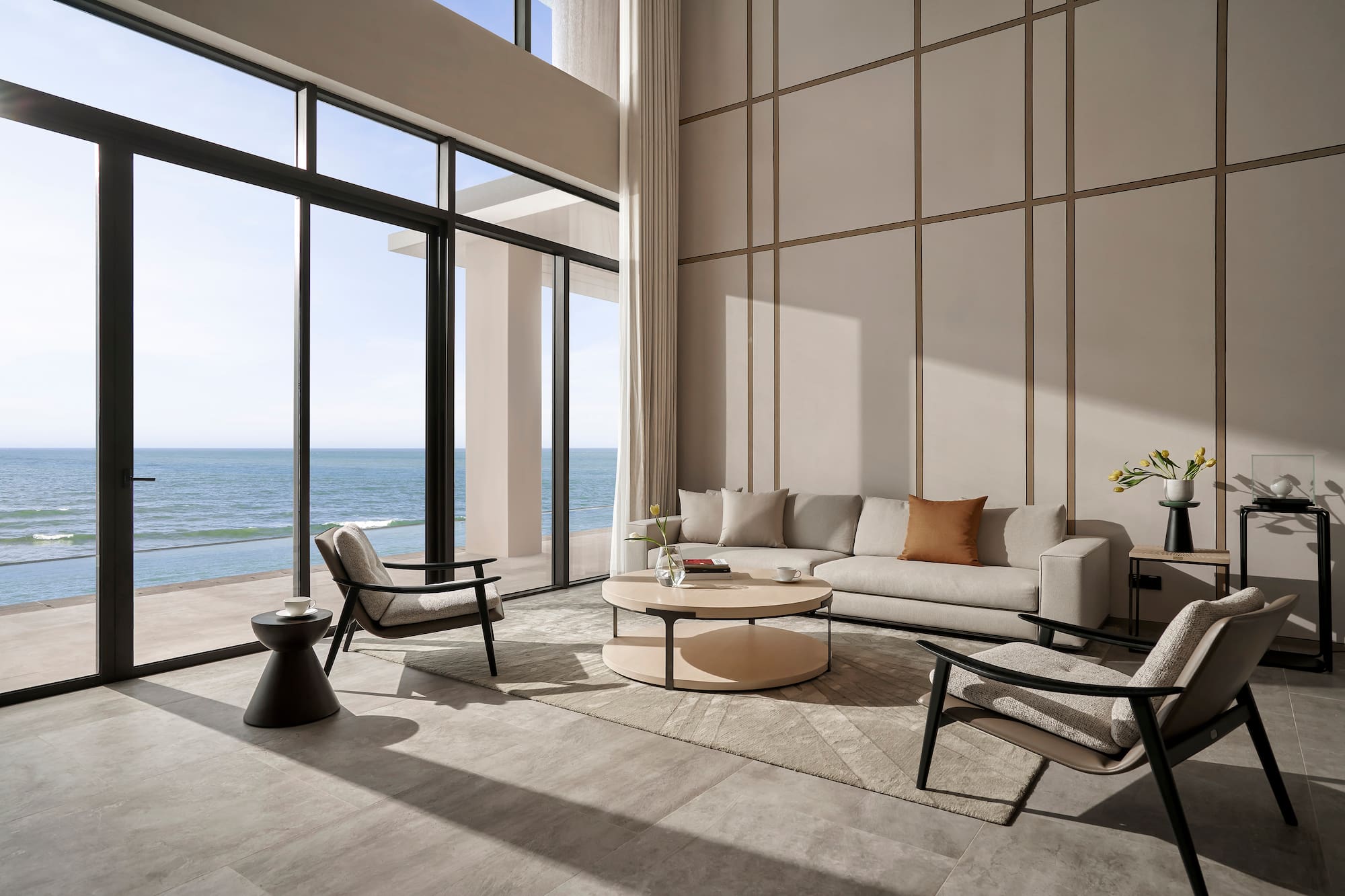 a living room with a large window overlooking the ocean