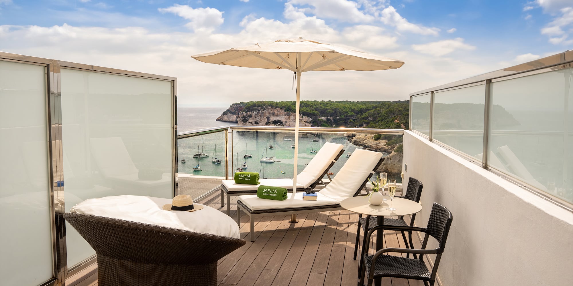 a deck with chairs and umbrellas overlooking a body of water