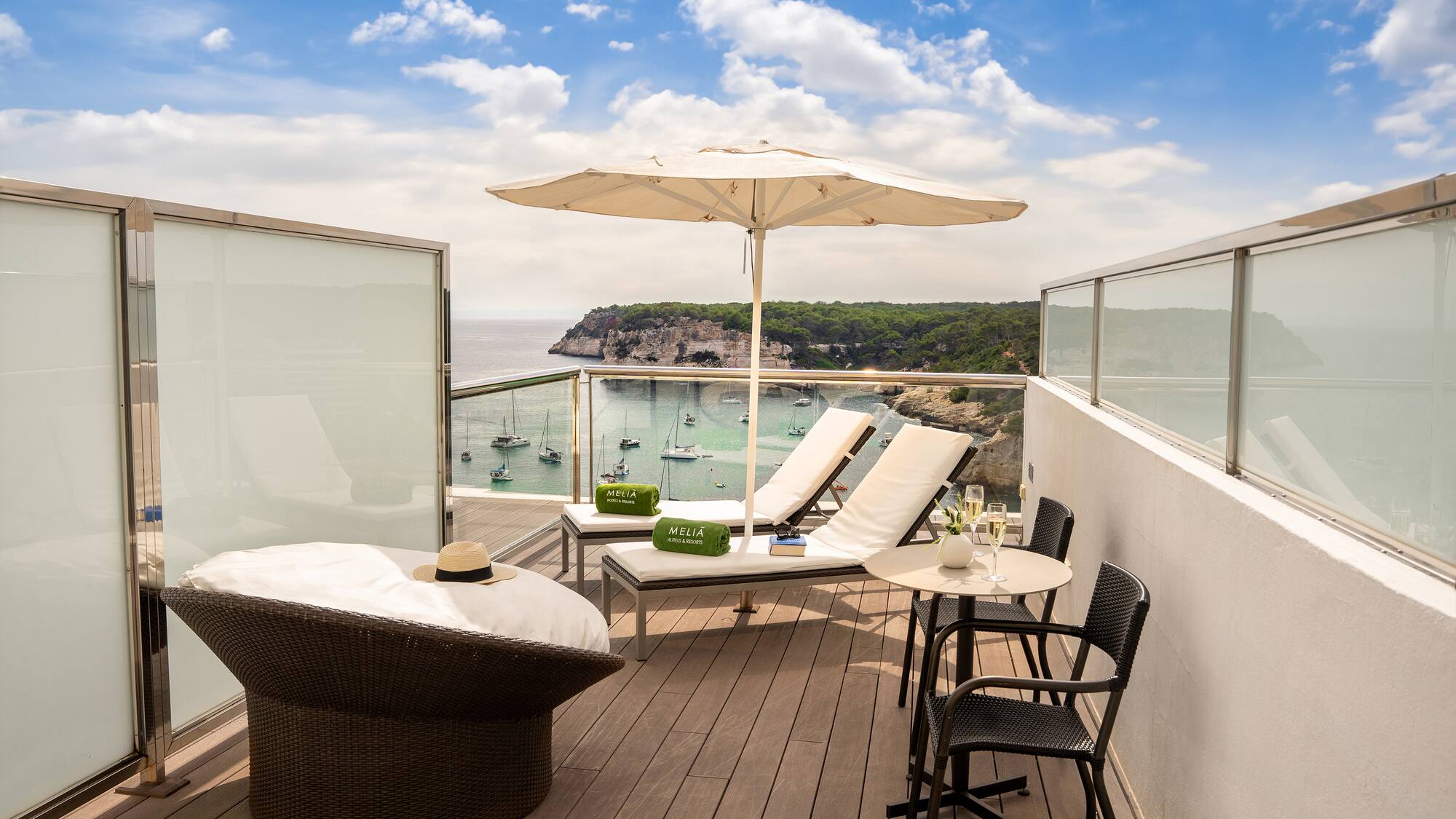 a deck with chairs and umbrellas overlooking a body of water
