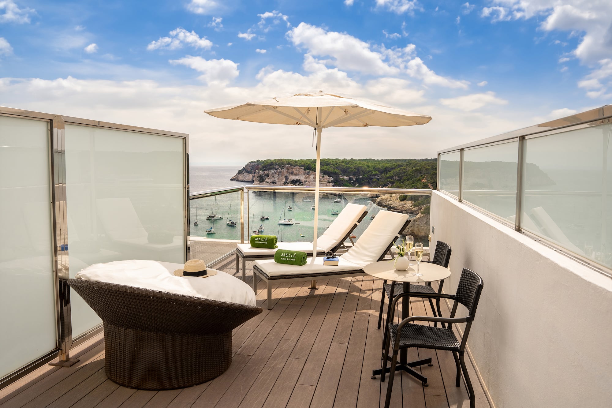 a deck with chairs and umbrellas overlooking a body of water