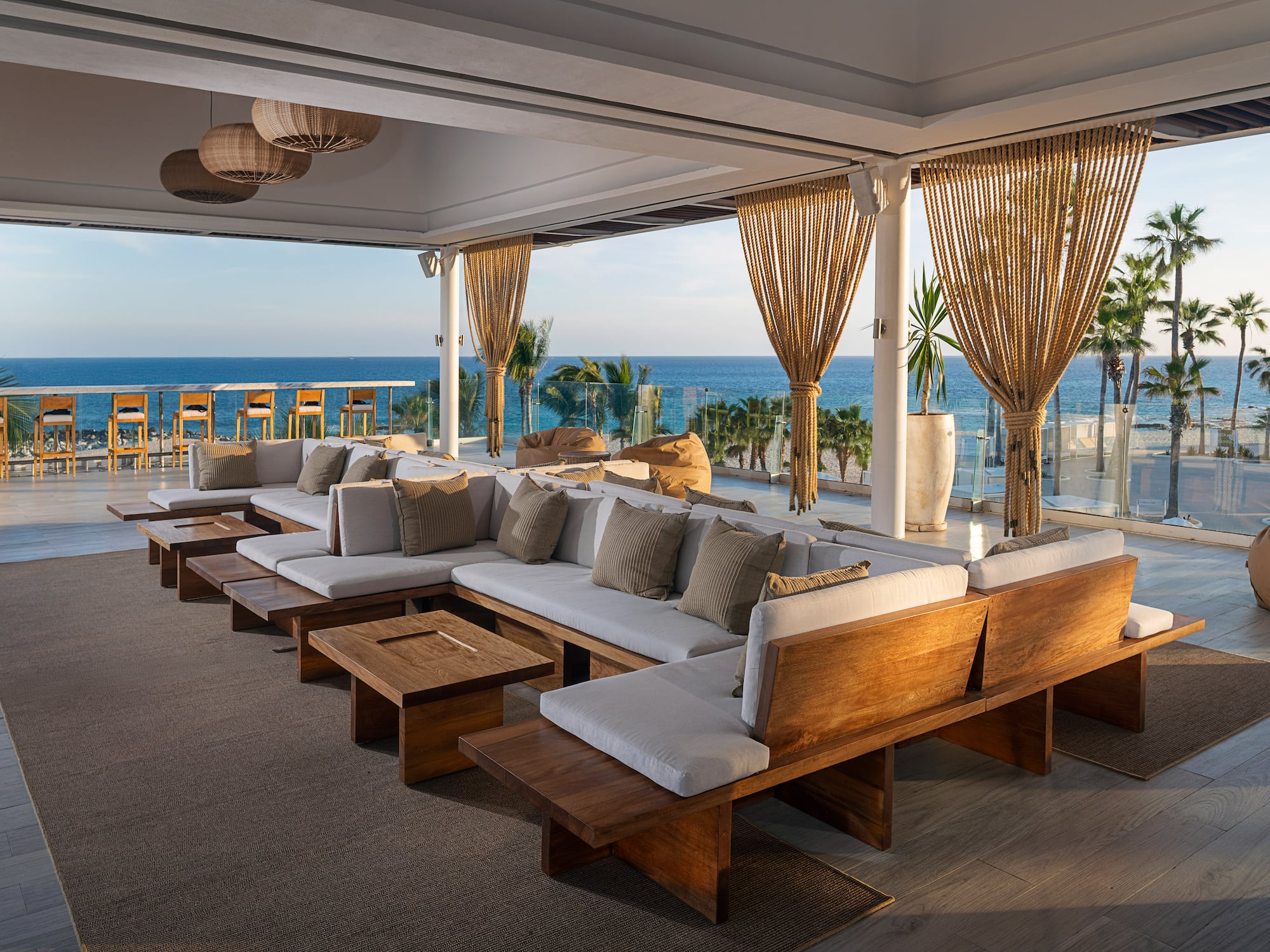 a large couches and tables in a room with a view of the ocean