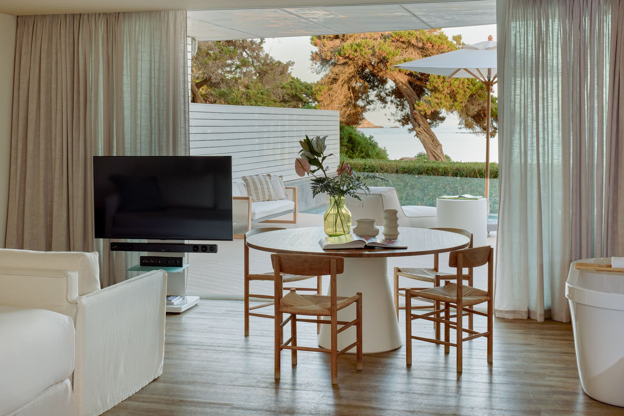 Open-plan living room with dining, TV, and stunning sea view patio.