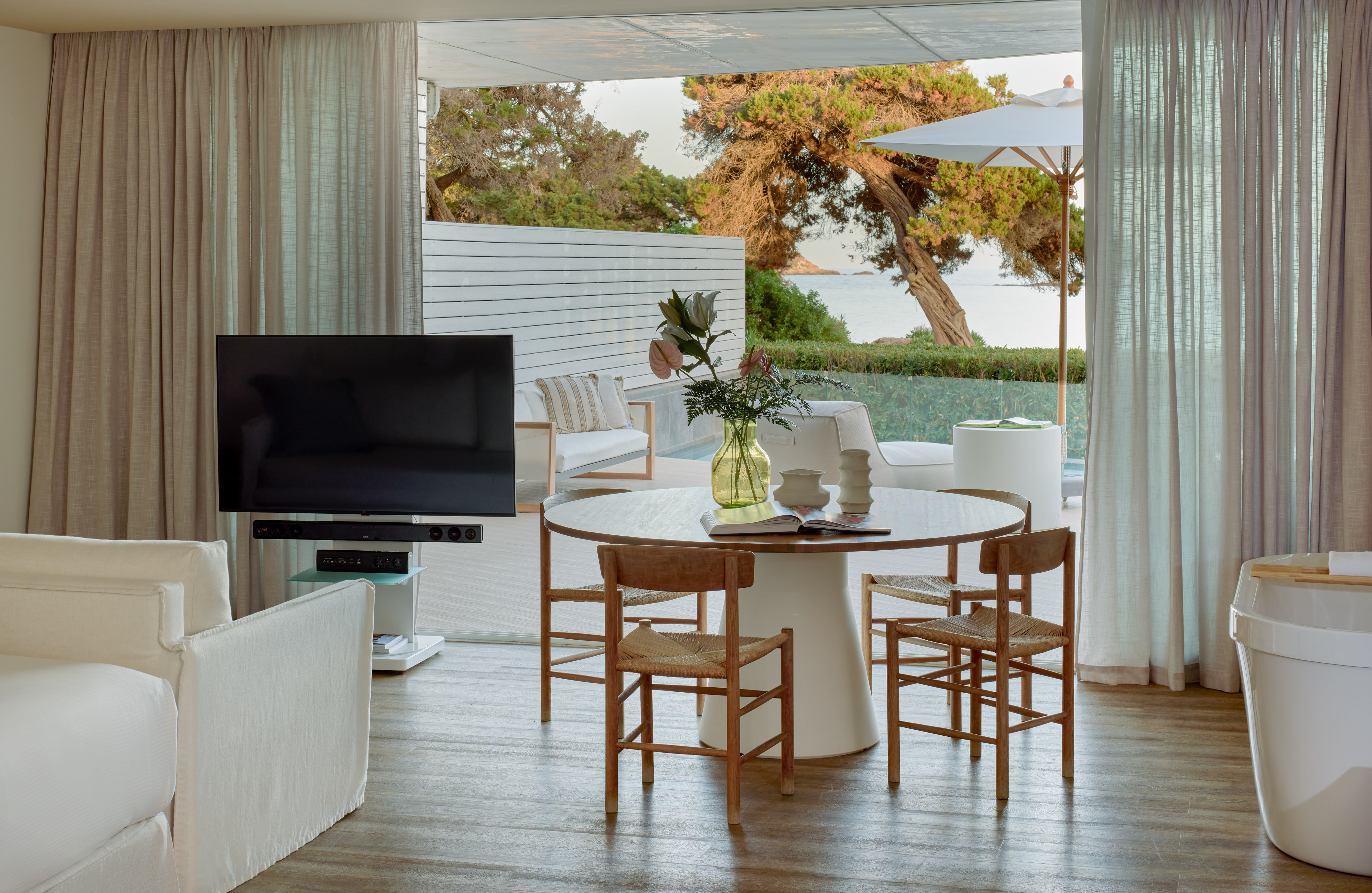 Open-plan living room with dining, TV, and stunning sea view patio.