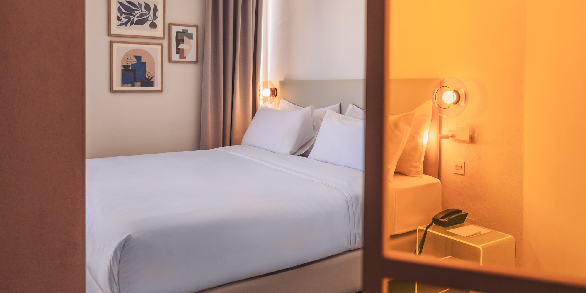 a bed with white sheets and pillows in a room