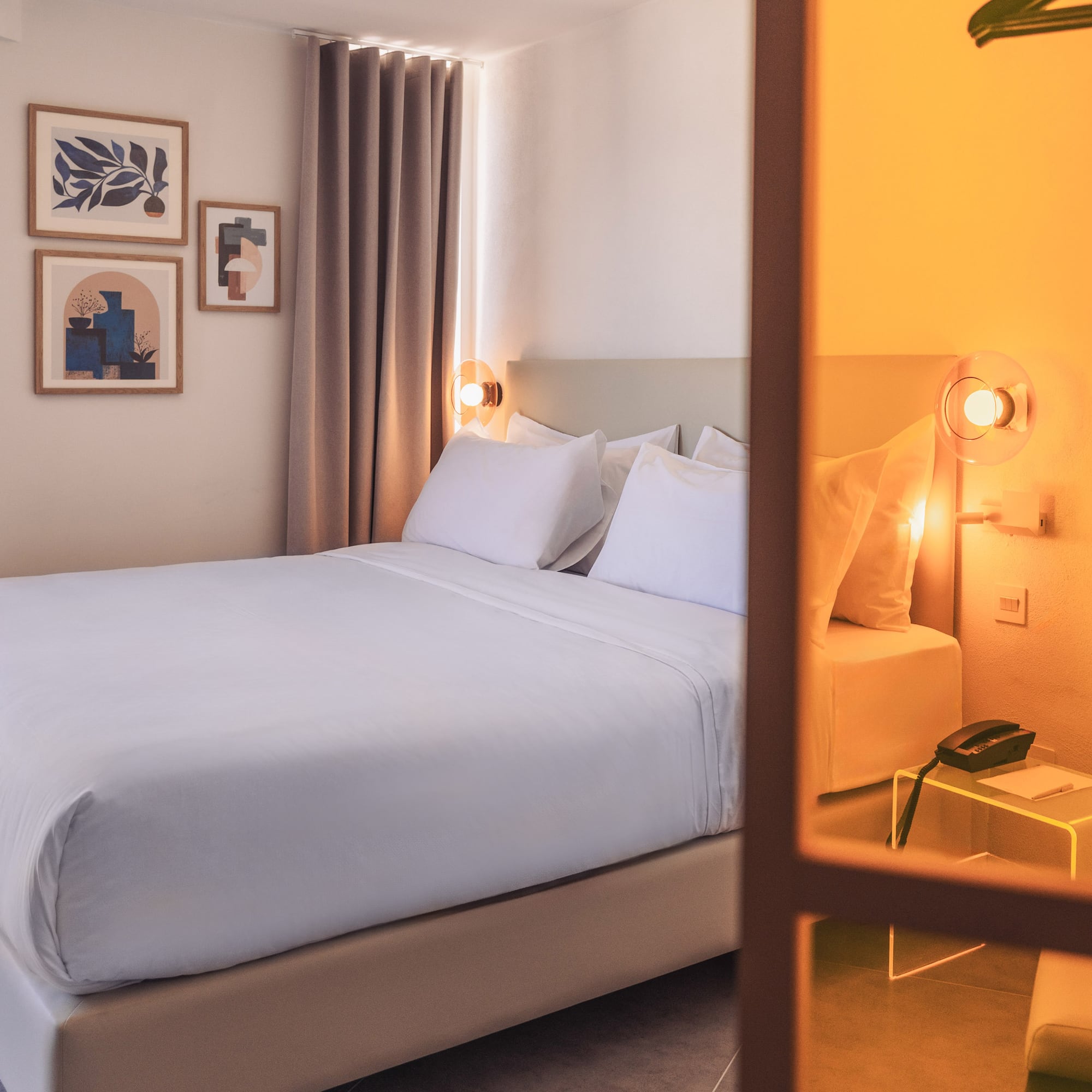 a bed with white sheets and pillows in a room