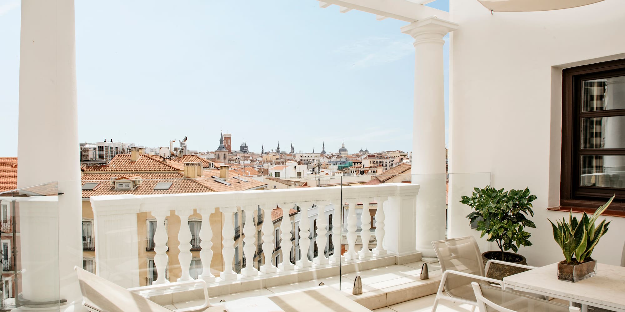 a balcony with chairs and a view of the city