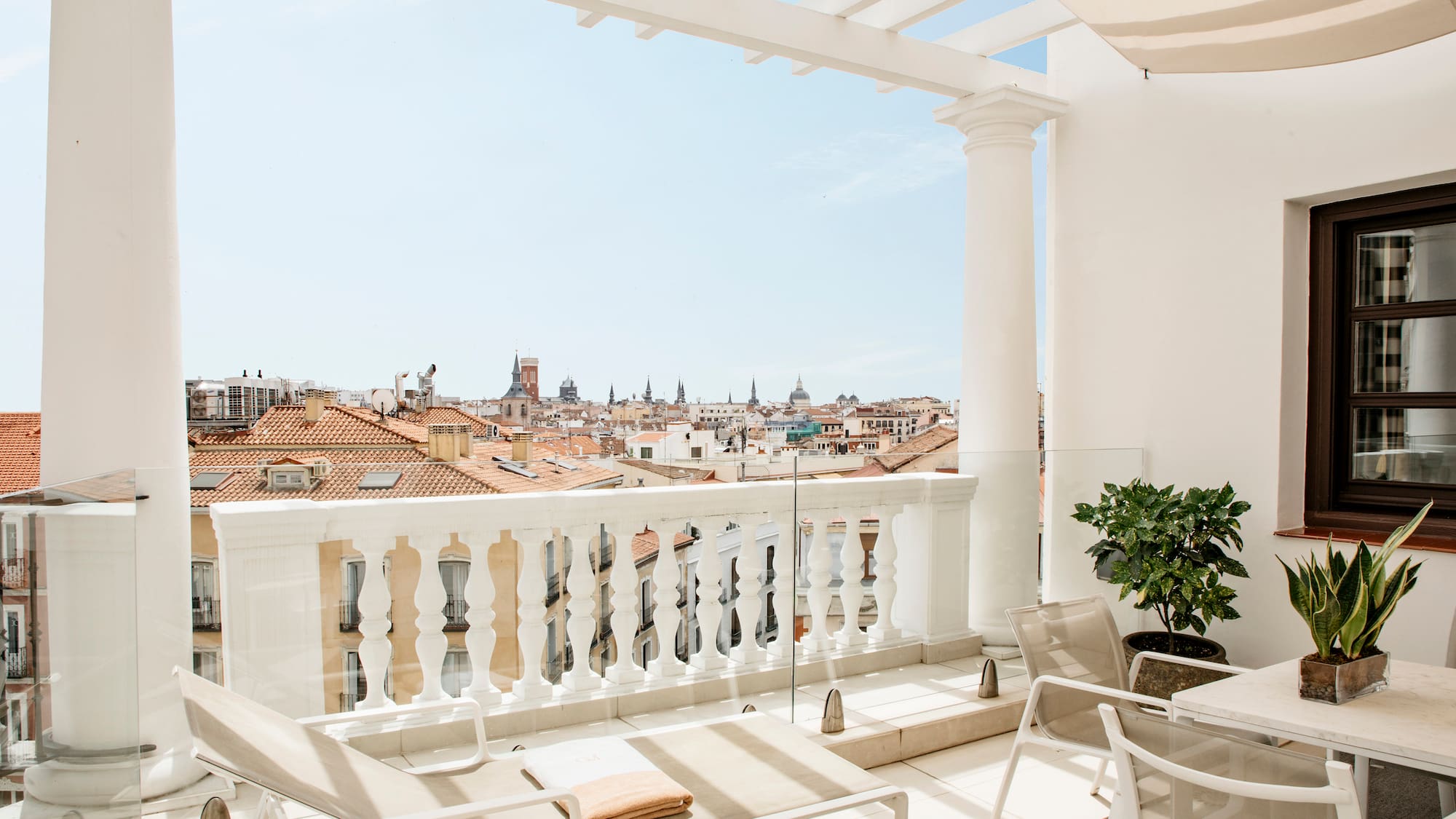 a balcony with chairs and a view of the city