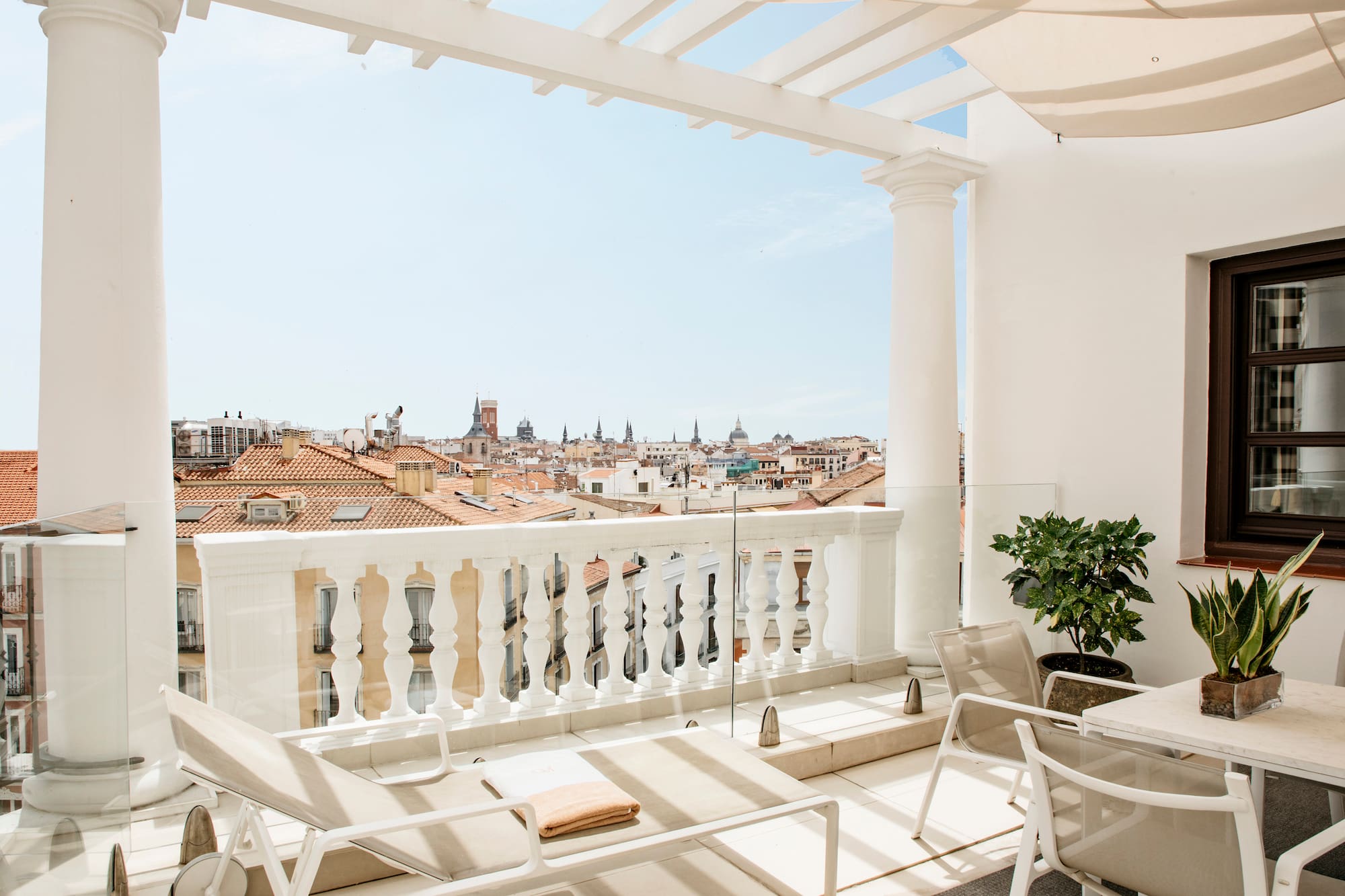 a balcony with chairs and a view of the city