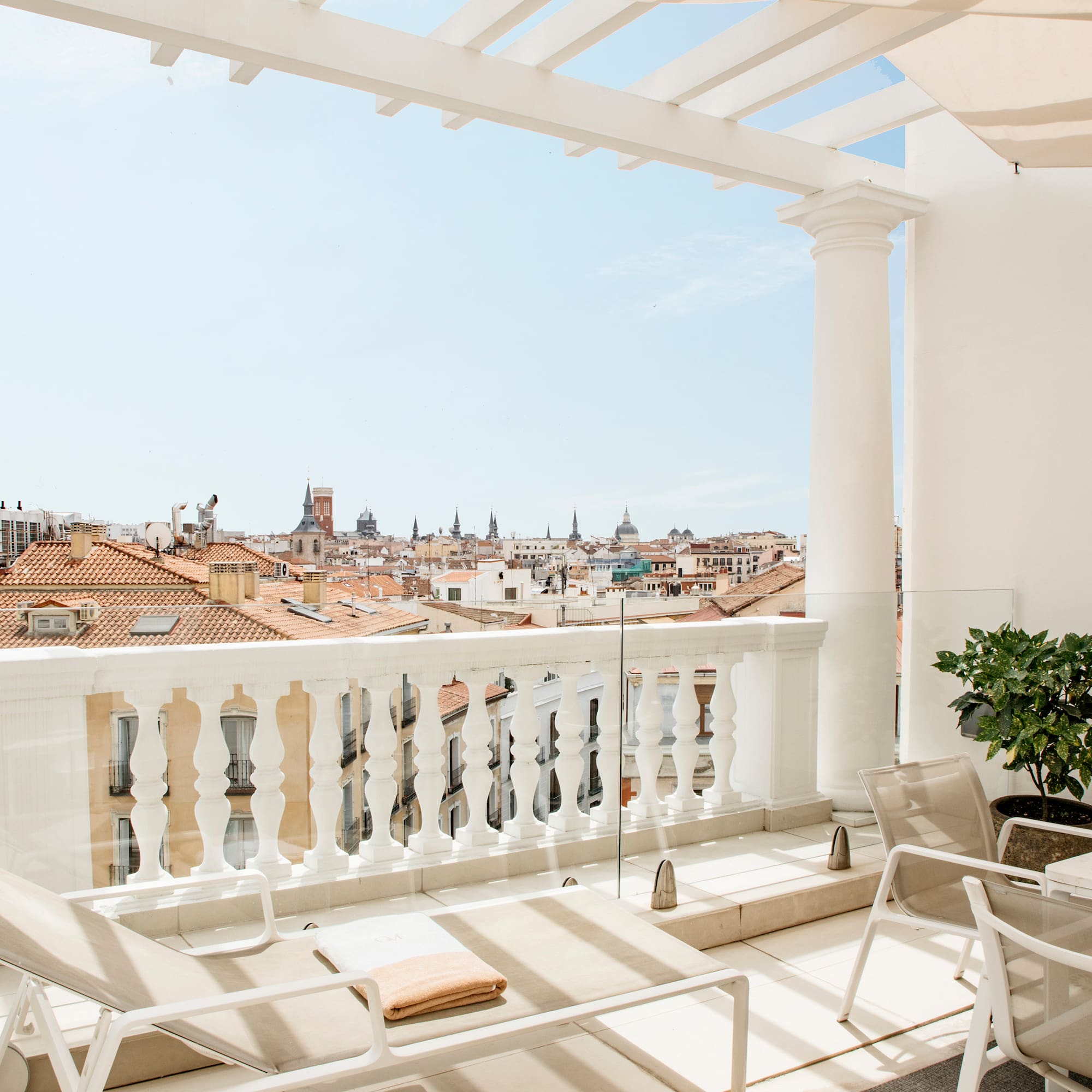 a balcony with chairs and a view of the city