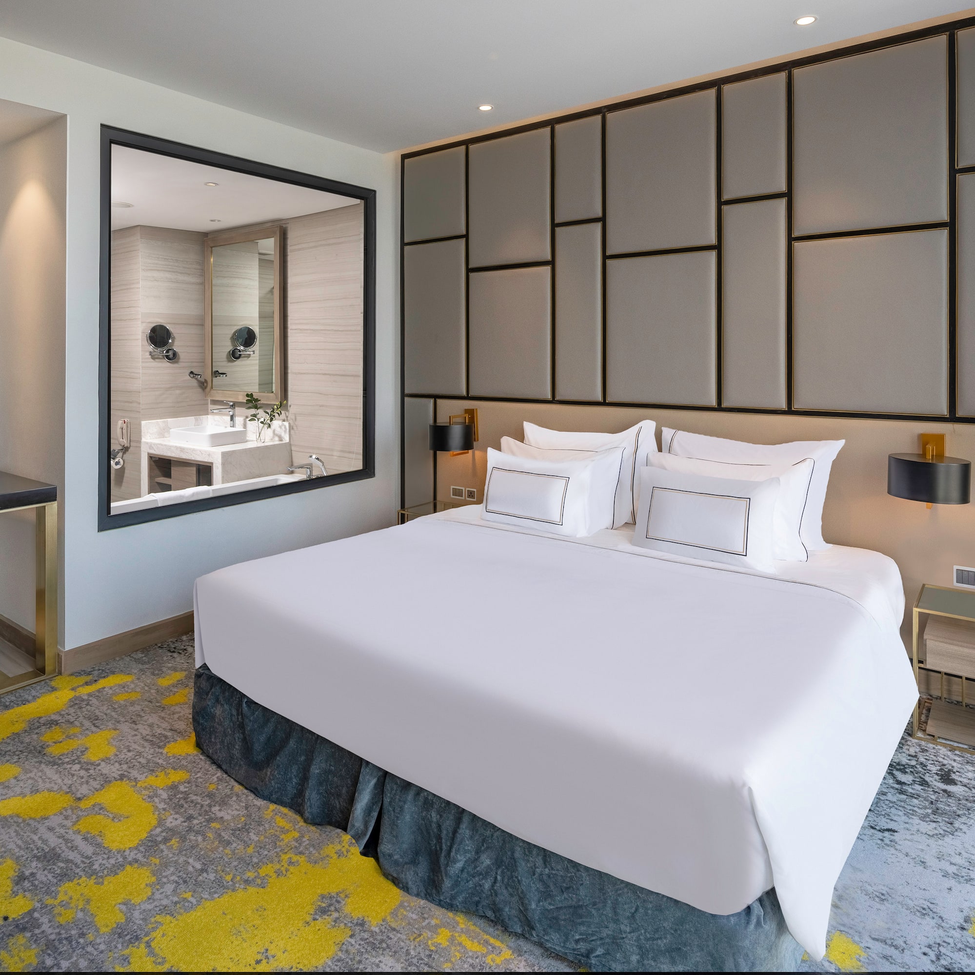 a bed with white sheets and a mirror in a room