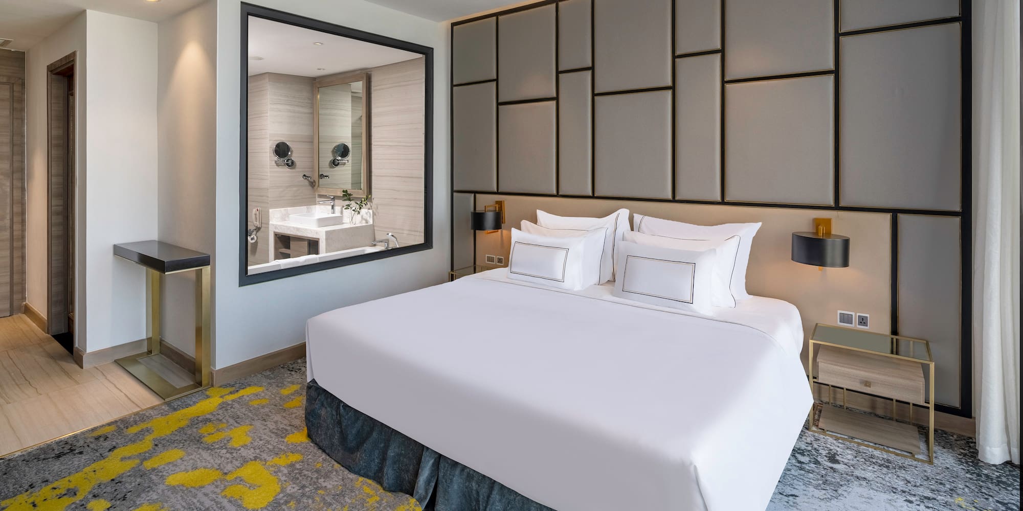 a bed with white sheets and a mirror in a room