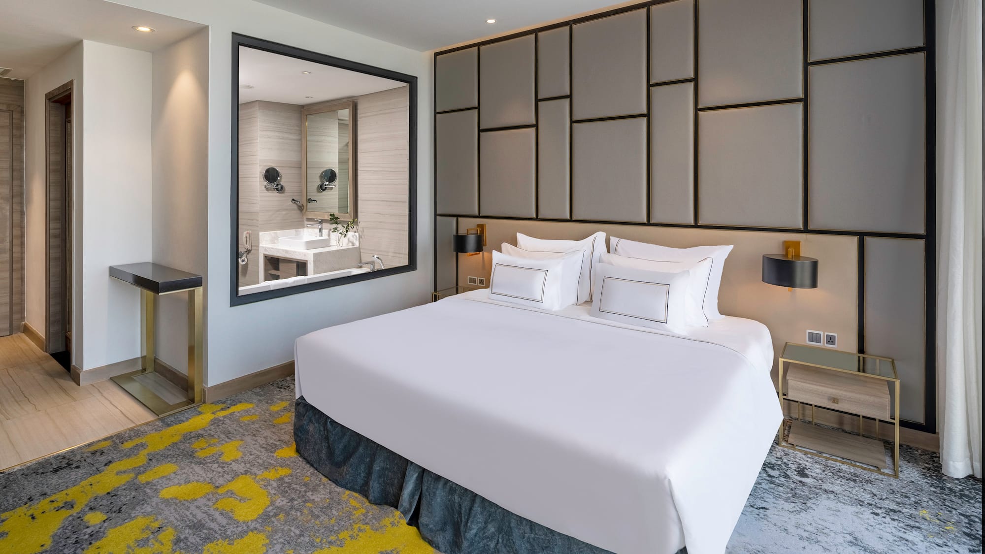 a bed with white sheets and a mirror in a room