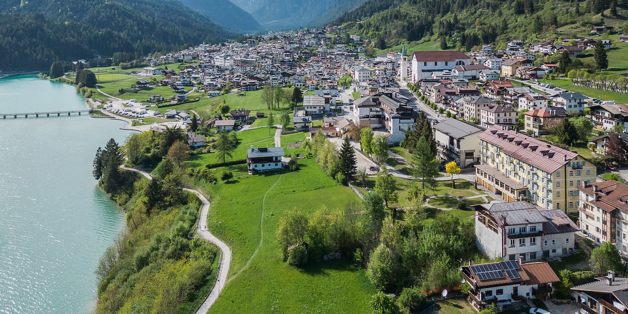Auronzo di Cadore: Alpine village, turquoise lake, and towering Dolomites peaks.