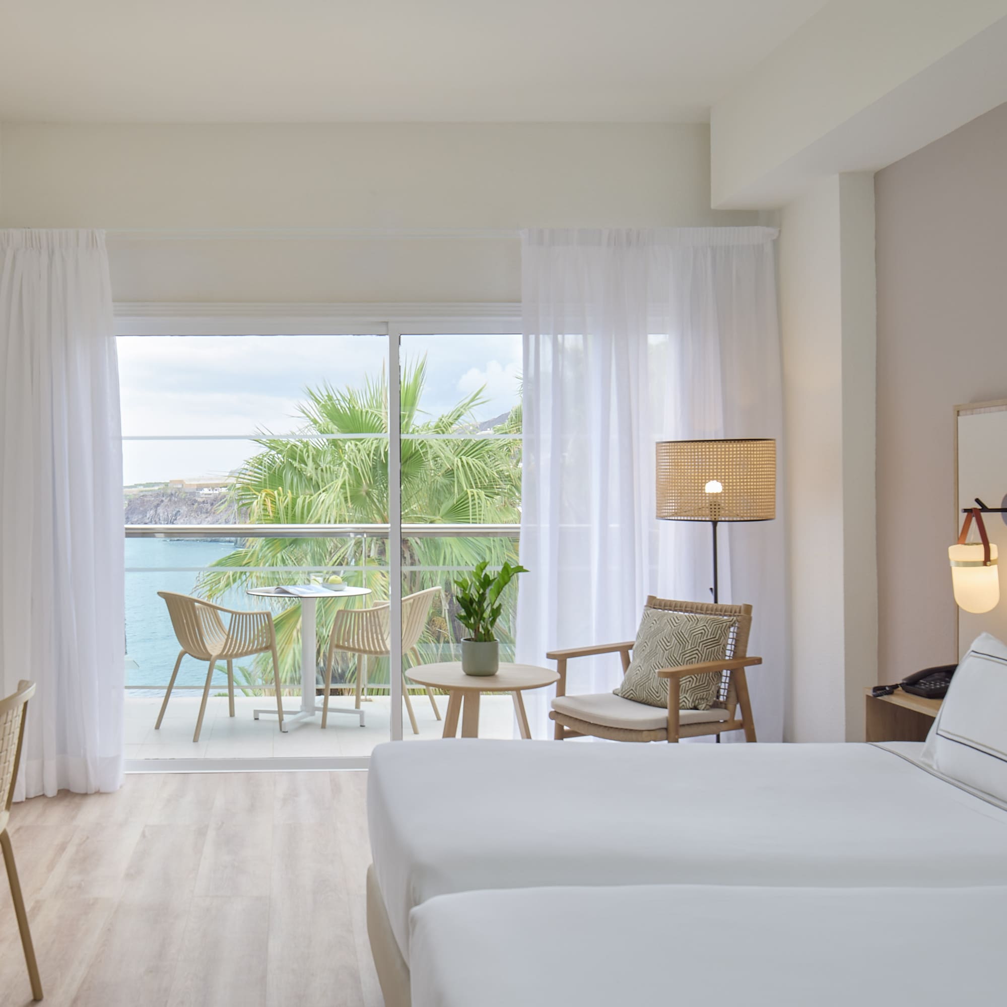a room with a view of the ocean and a table and chairs