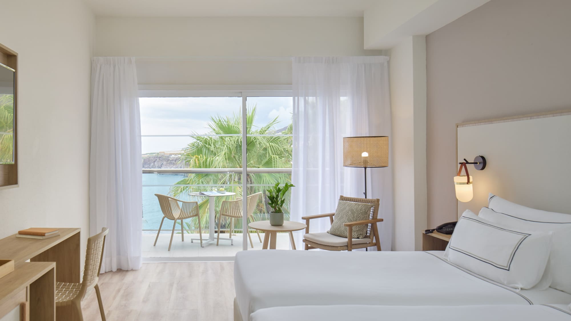 a room with a view of the ocean and a table and chairs