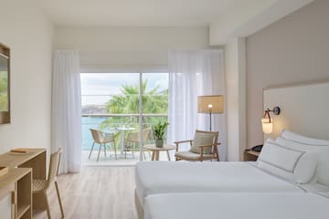 a room with a view of the ocean and a table and chairs