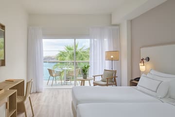 a room with a view of the ocean and a table and chairs