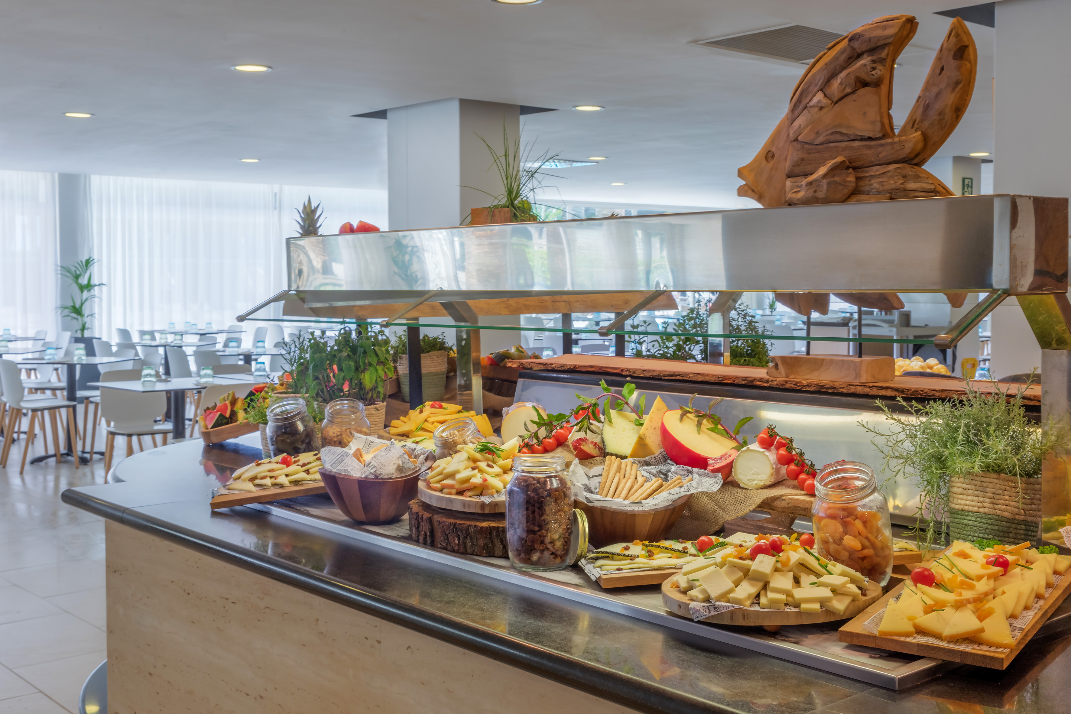 Hotel buffet with gourmet cheese, crackers, fruits, and snacks.
