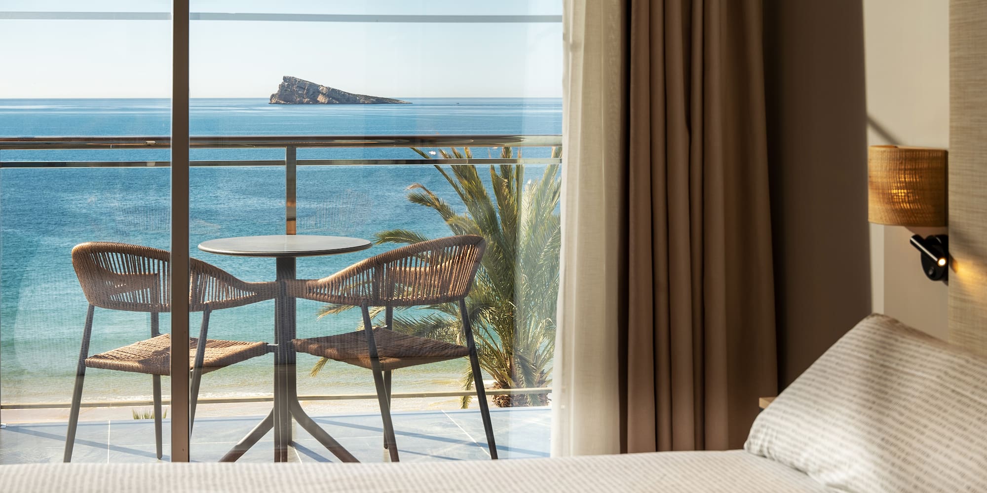 a room with a table and chairs overlooking the ocean