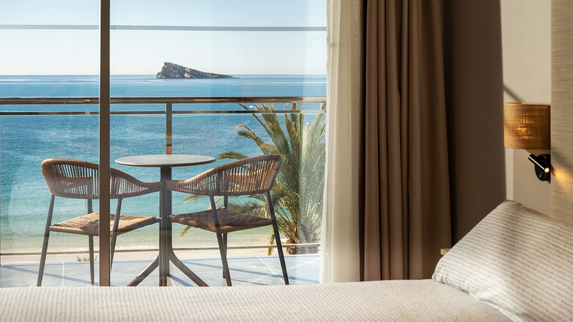 a room with a table and chairs overlooking the ocean