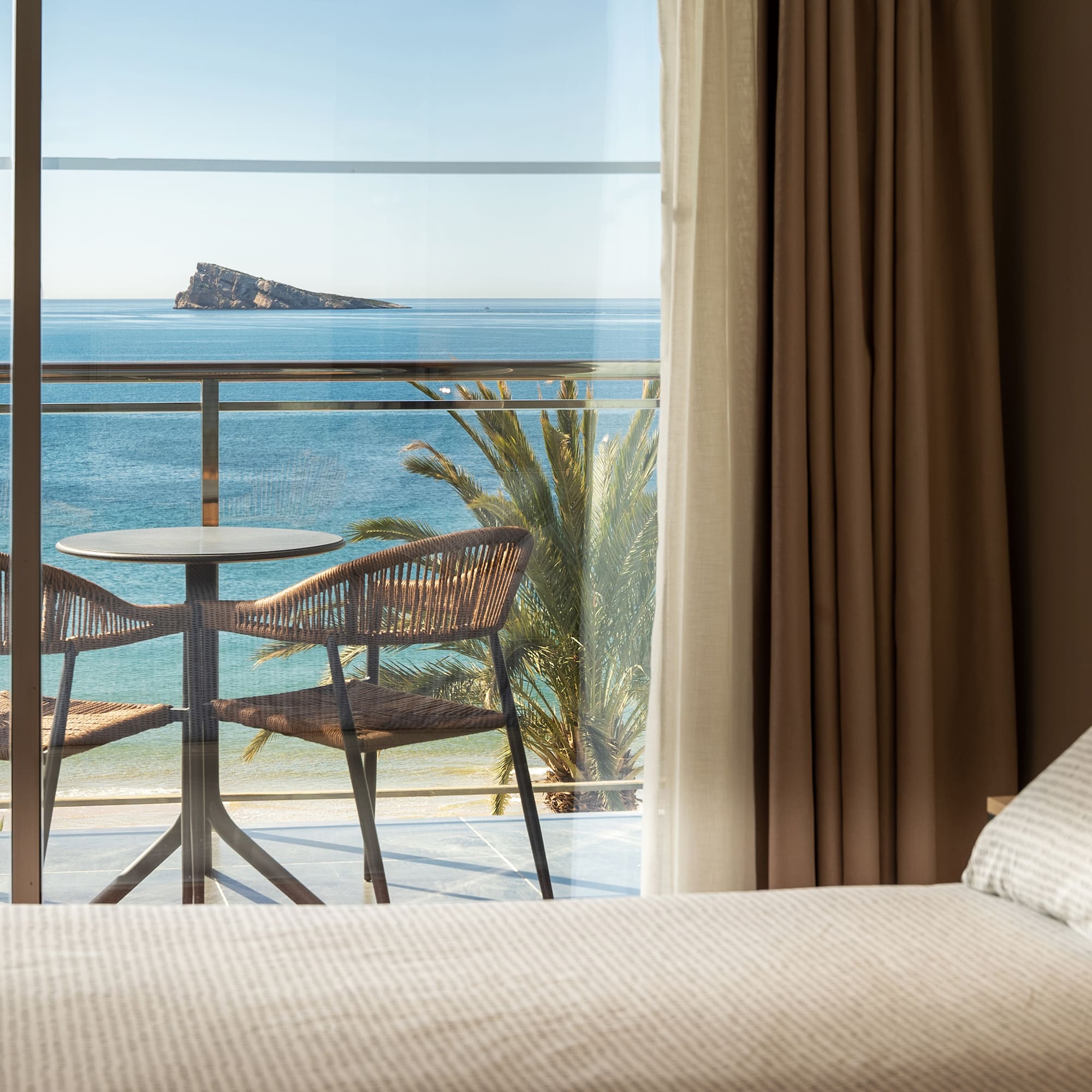 a room with a table and chairs overlooking the ocean