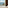 Hotel room balcony with wicker chairs, ocean view, distant island, and beach.
