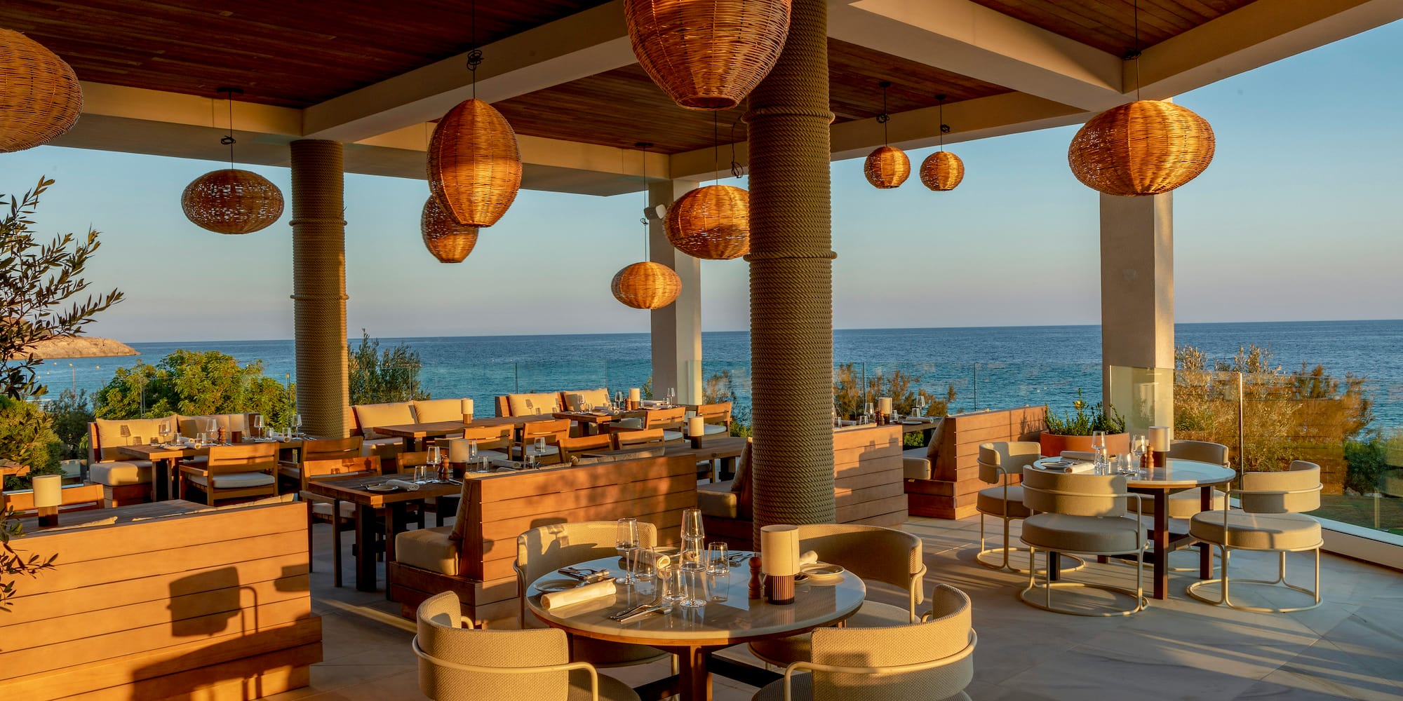 a restaurant with tables and chairs and a view of the ocean